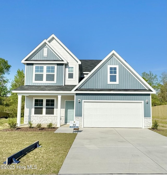 200 Flora Field Dr, Jacksonville, NC 28546 - craftsman-style home with a front yard, stone siding, a garage, board and batten siding, and concrete driveway