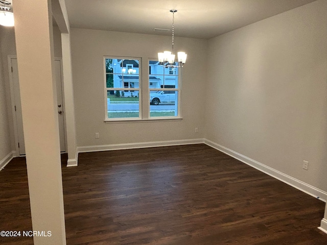 empty room featuring dark hardwood / wood-style floors and a chandelier