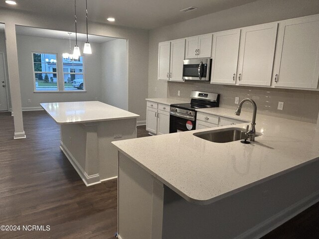 kitchen featuring decorative light fixtures, stainless steel appliances, sink, dark hardwood / wood-style floors, and white cabinets