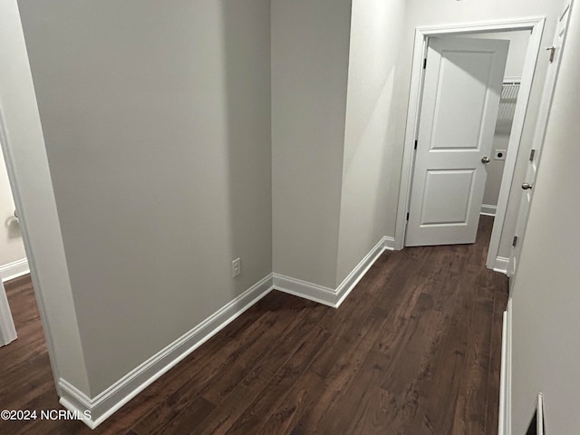 corridor with dark hardwood / wood-style flooring