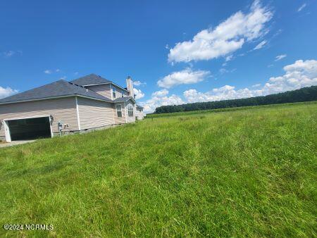 view of yard with a garage and a rural view