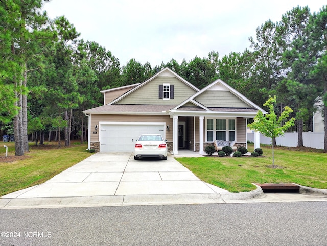 craftsman-style house featuring a front yard, a garage, and covered porch