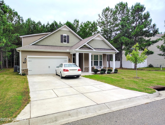 view of front facade with a front lawn, central AC unit, covered porch, and a garage