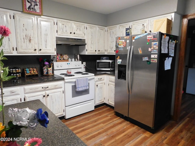 kitchen with hardwood / wood-style floors, stainless steel appliances, and white cabinets