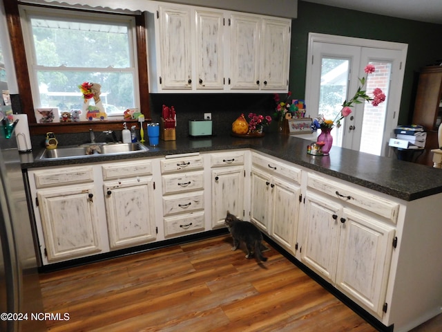 kitchen featuring wood-type flooring, kitchen peninsula, and sink