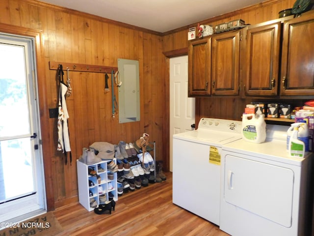 laundry area featuring light hardwood / wood-style floors, cabinets, washing machine and dryer, and plenty of natural light