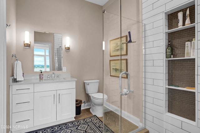 bathroom featuring tile patterned floors, vanity, toilet, and an enclosed shower