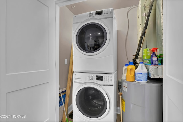 clothes washing area with stacked washing maching and dryer and water heater