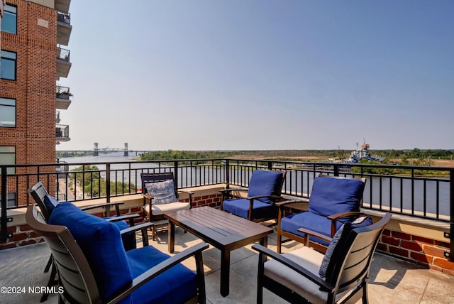 view of patio / terrace featuring an outdoor living space, a balcony, and a water view