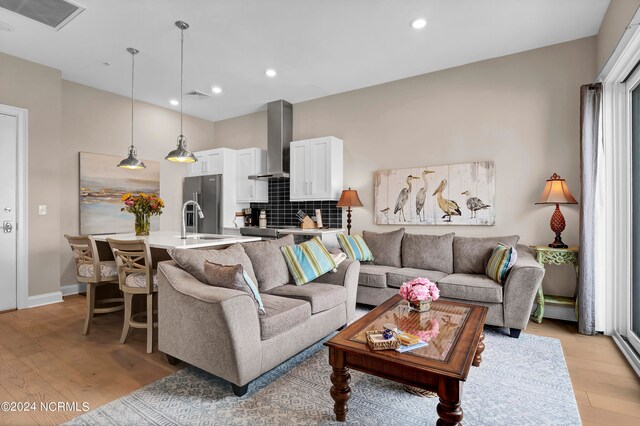 living room with light wood-type flooring and sink