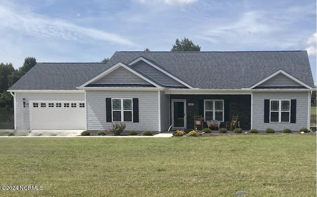 view of front of property with a garage, covered porch, and a front yard