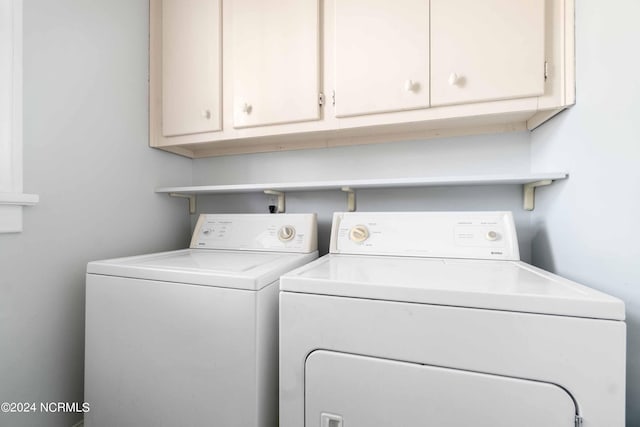 washroom featuring cabinets and washing machine and dryer