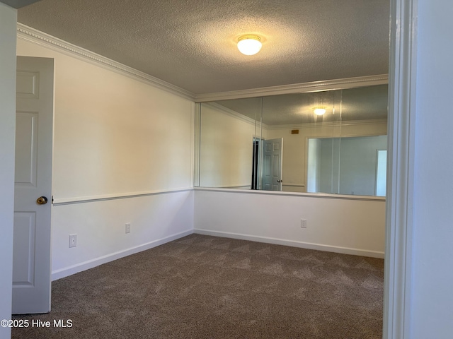 unfurnished room with ornamental molding, dark colored carpet, and a textured ceiling