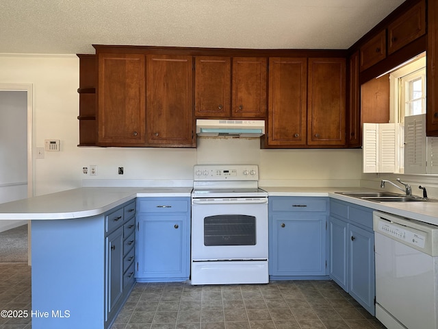 kitchen with sink, white appliances, kitchen peninsula, and a textured ceiling