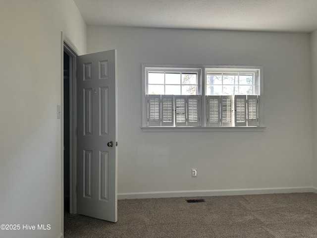 carpeted spare room featuring a textured ceiling