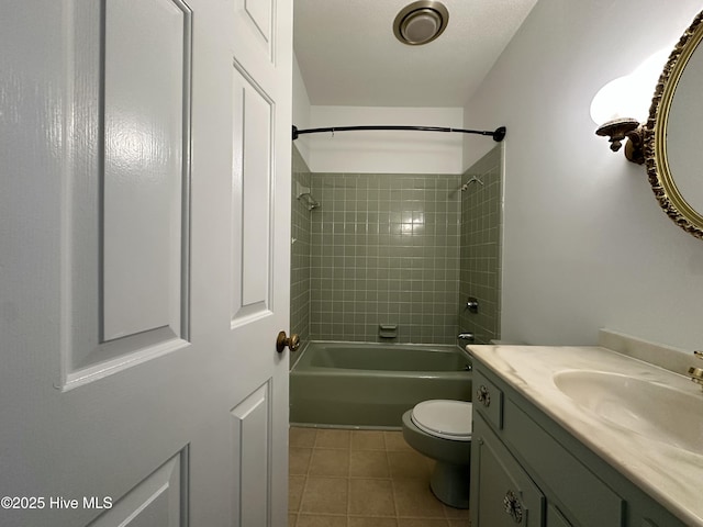 full bathroom featuring toilet, tiled shower / bath, tile patterned flooring, and vanity