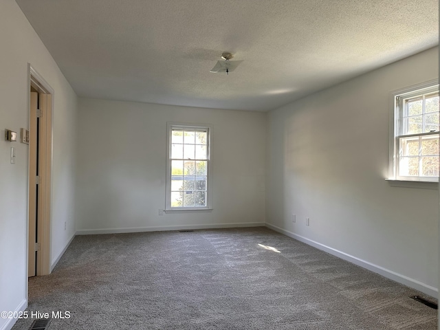 carpeted spare room with a textured ceiling