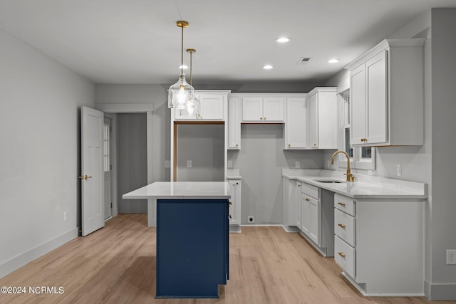 kitchen featuring light hardwood / wood-style floors, sink, a center island, and white cabinetry