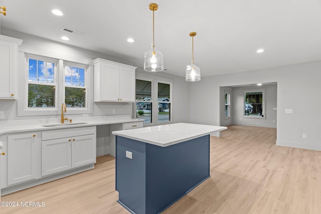 kitchen featuring white cabinets, light hardwood / wood-style flooring, and sink