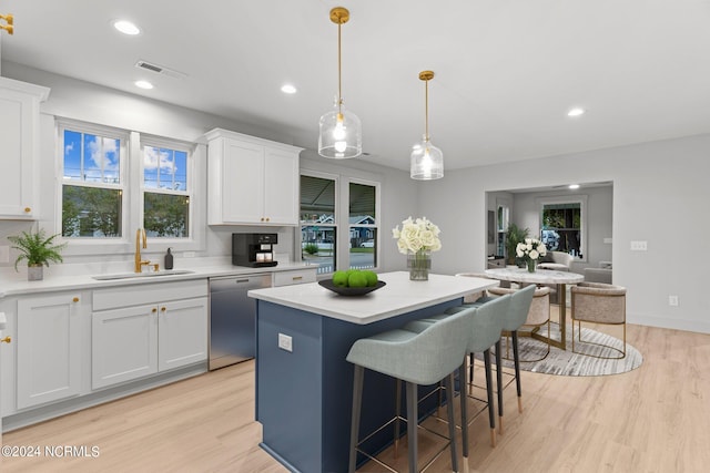 kitchen featuring a kitchen island, white cabinetry, sink, and dishwasher