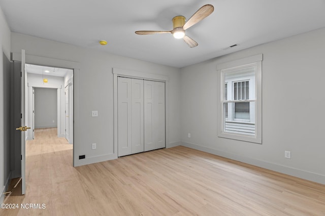 unfurnished bedroom featuring a closet, light hardwood / wood-style floors, and ceiling fan