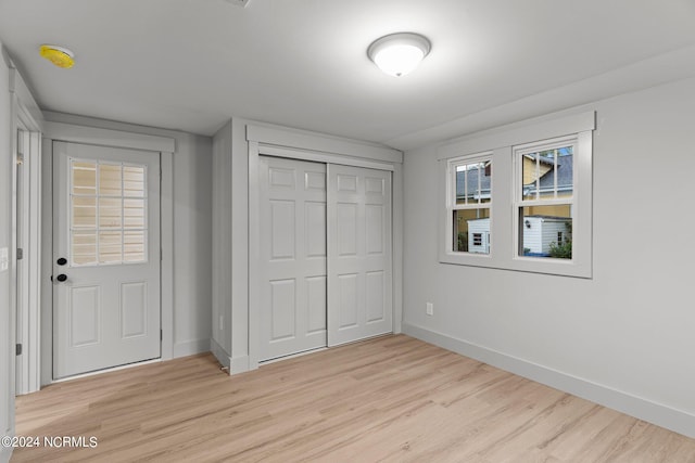 unfurnished bedroom featuring a closet and light wood-type flooring