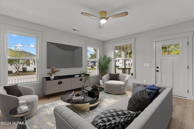 living room with light wood-type flooring, a wealth of natural light, and ceiling fan