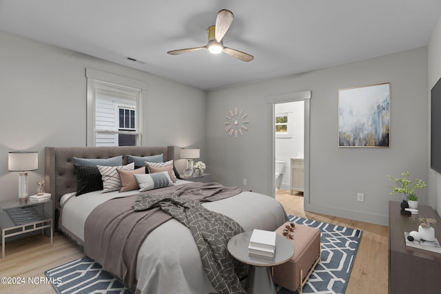 bedroom featuring connected bathroom, light wood-type flooring, and ceiling fan