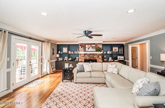 living room featuring ceiling fan, a brick fireplace, french doors, hardwood / wood-style flooring, and crown molding