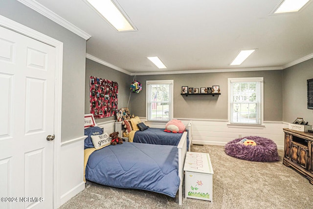 bedroom with carpet floors, wooden walls, crown molding, and multiple windows