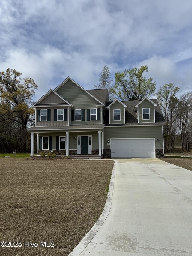 view of front of property with a yard, a porch, and a garage