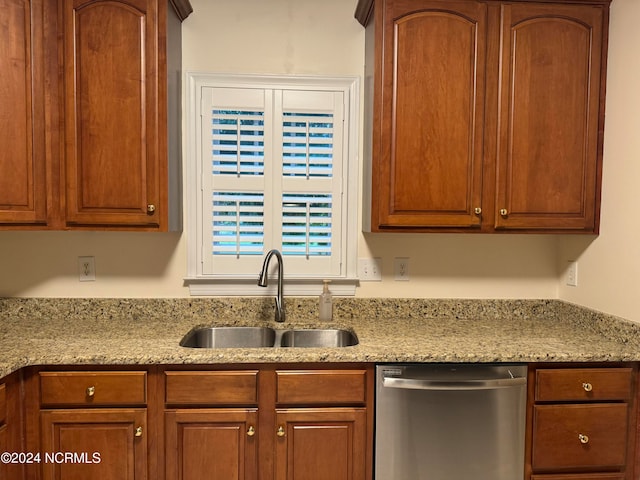 kitchen featuring light stone countertops, stainless steel dishwasher, and sink