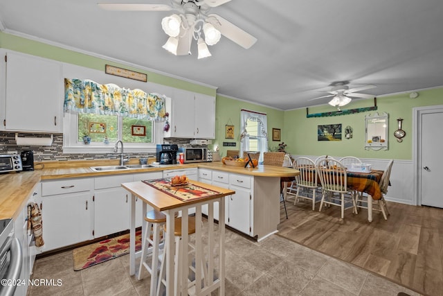 kitchen with ceiling fan and white cabinets