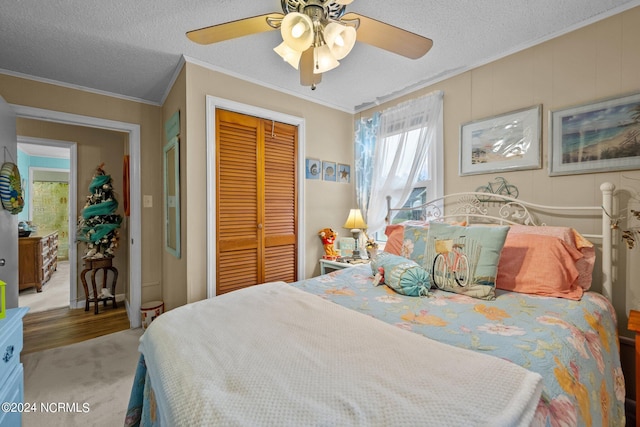 bedroom with a textured ceiling, crown molding, ceiling fan, and a closet