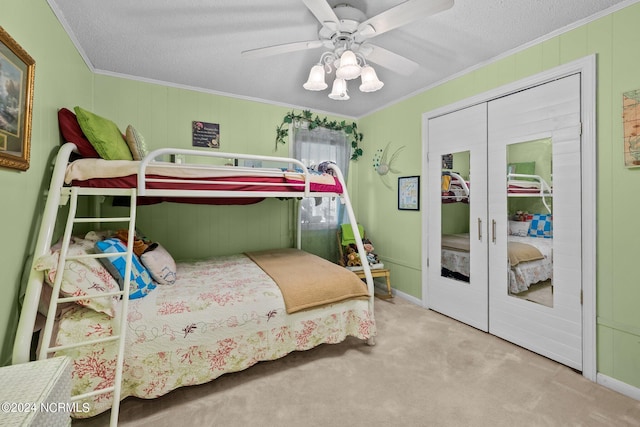 bedroom featuring carpet floors, a textured ceiling, ornamental molding, and ceiling fan