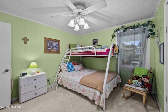 bedroom featuring a textured ceiling, ornamental molding, ceiling fan, and light colored carpet