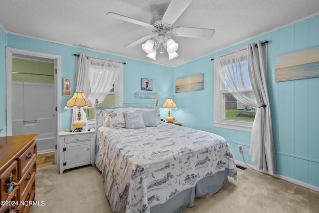 carpeted bedroom featuring ceiling fan, a textured ceiling, and crown molding