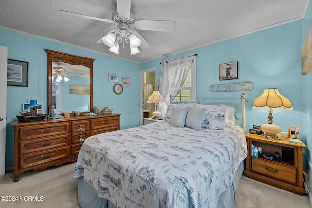 carpeted bedroom with ornamental molding, ceiling fan, and a textured ceiling