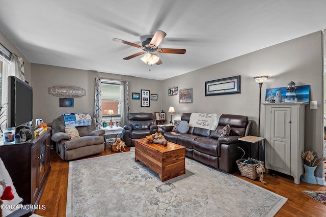 living room with dark wood-type flooring and ceiling fan