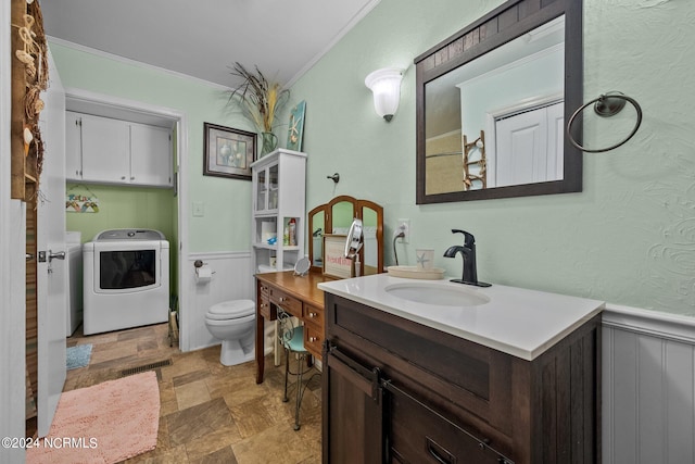 bathroom featuring washer and clothes dryer, toilet, vanity, and crown molding