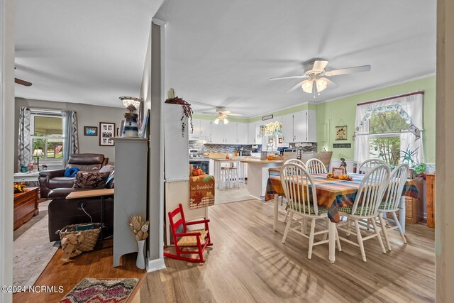 dining area with ceiling fan, light hardwood / wood-style flooring, and ornamental molding