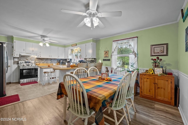 dining room with ceiling fan, ornamental molding, and light hardwood / wood-style floors