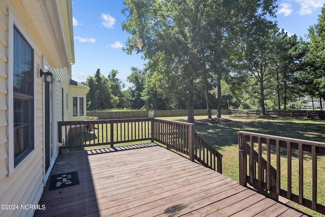 wooden terrace featuring a lawn