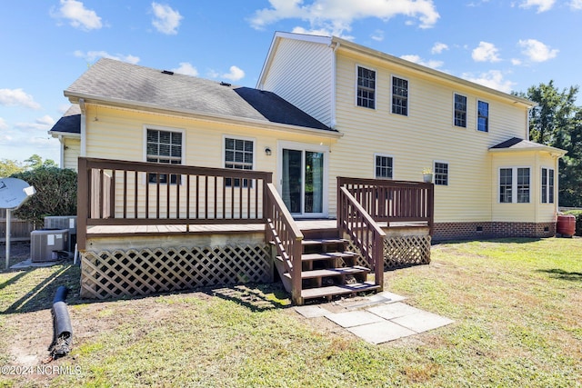 rear view of property featuring a lawn, central AC, and a deck