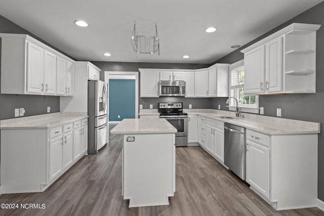 kitchen with white cabinets, stainless steel appliances, sink, and a kitchen island