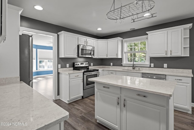 kitchen with stainless steel appliances, white cabinets, and sink