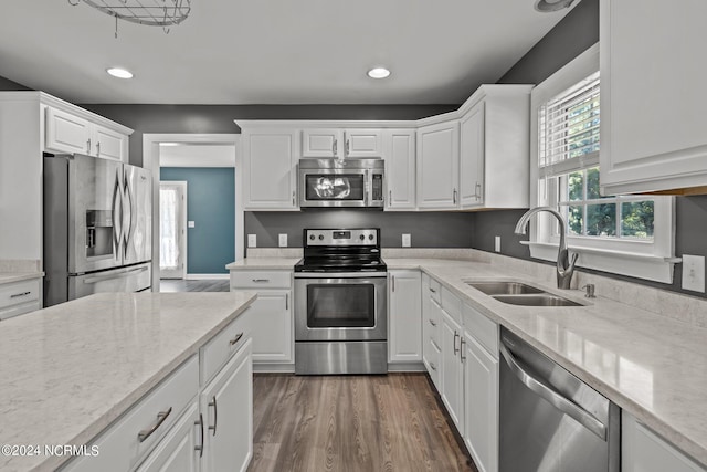 kitchen featuring light stone counters, white cabinets, sink, dark wood-type flooring, and appliances with stainless steel finishes