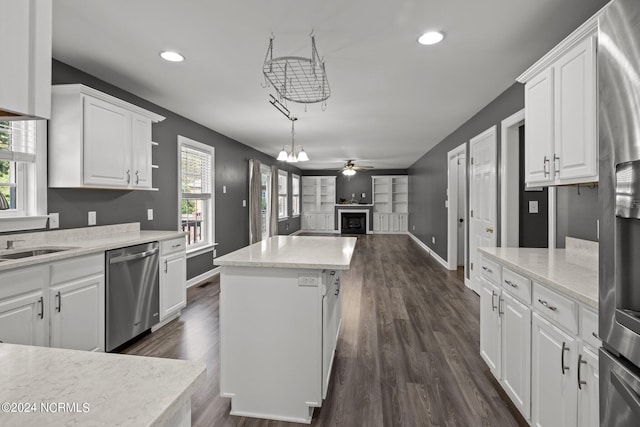 kitchen with a center island, ceiling fan with notable chandelier, white cabinets, stainless steel appliances, and dark hardwood / wood-style flooring