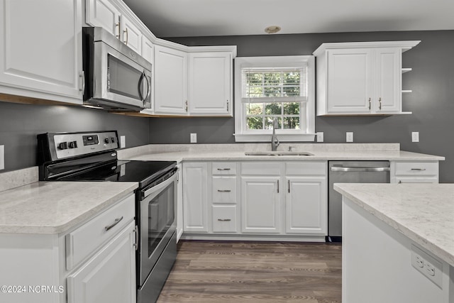 kitchen with white cabinets, appliances with stainless steel finishes, dark hardwood / wood-style floors, and sink