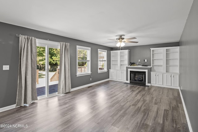 unfurnished living room featuring ceiling fan and dark hardwood / wood-style flooring